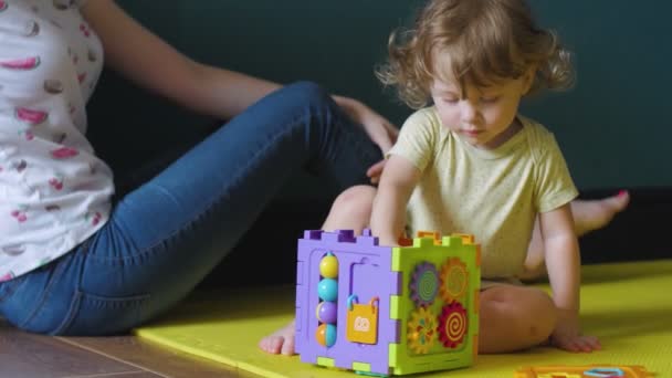 Mother and Curly daughter are playing with Sorter Cube — Stock Video