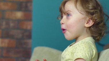 Küçük kız el sallıyor ve gülüyor