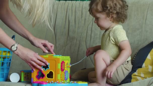 Little girl is playing with Activity Sorter Cube — Stock Video