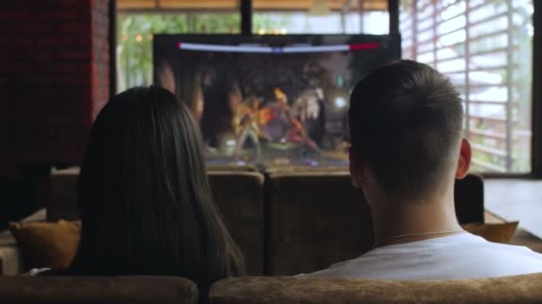 Zpět pohled na člověka a jeho přítelkyně hraje televizní hru — Stock video