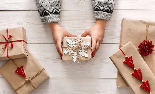 Womans hands show christmas holiday present with craft twine