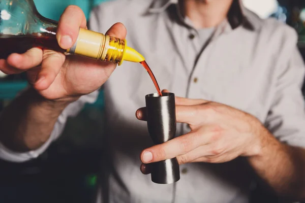 Barmans jóvenes haciendo cóctel de tiro, vertiendo jarabe en el vaso — Foto de Stock