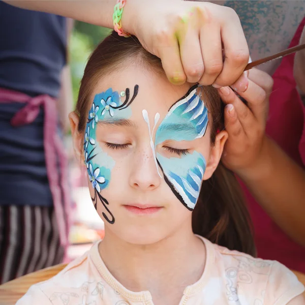 Feminino criança rosto pintura, fazendo processo de borboleta — Fotografia de Stock