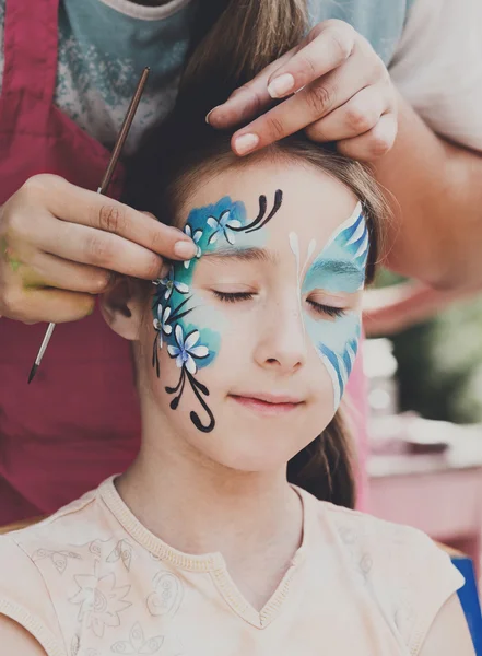 Feminino criança rosto pintura, fazendo processo de borboleta — Fotografia de Stock