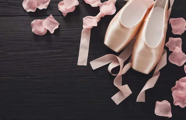 Zapatillas puntas de ballet rosa sobre fondo de madera negra —  Fotos de Stock