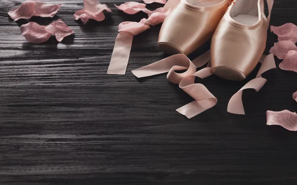 Zapatillas puntas de ballet rosa sobre fondo de madera negra —  Fotos de Stock