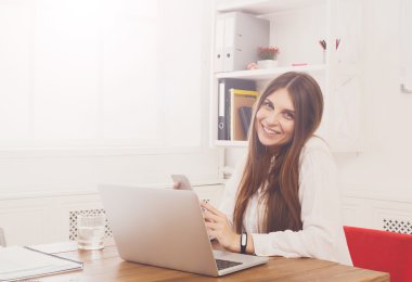 Ofis büro dizüstü bilgisayar ile başına oturmuş güzel genç iş kadını