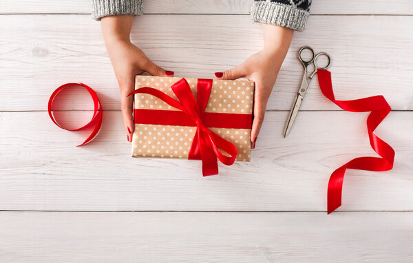 Womans hands give christmas gift in present box