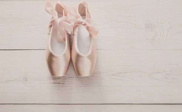 Zapatillas puntas de ballet rosa sobre fondo de madera blanca — Foto de Stock