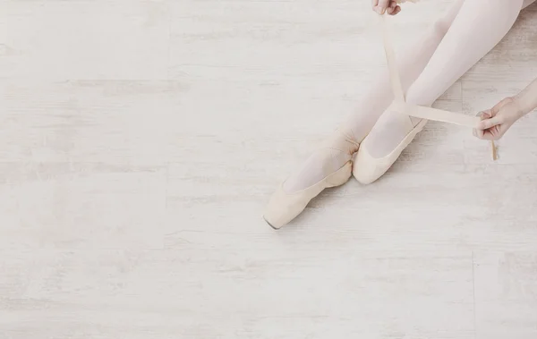 Ballerina zieht spitze Ballettschuhe an, anmutige Beine — Stockfoto