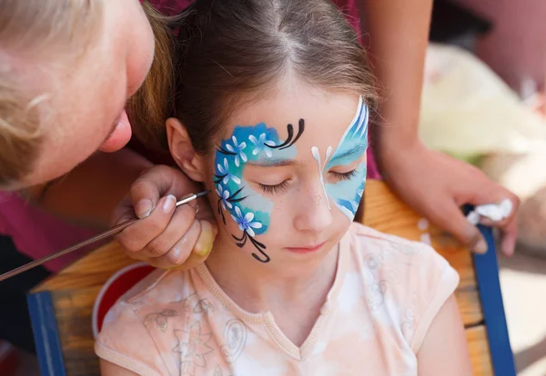 Feminino criança rosto pintura, fazendo processo de borboleta — Fotografia de Stock