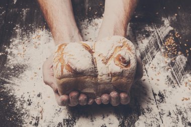 Fırın kavramı arka plan. Ekmek somun ellerini tutun