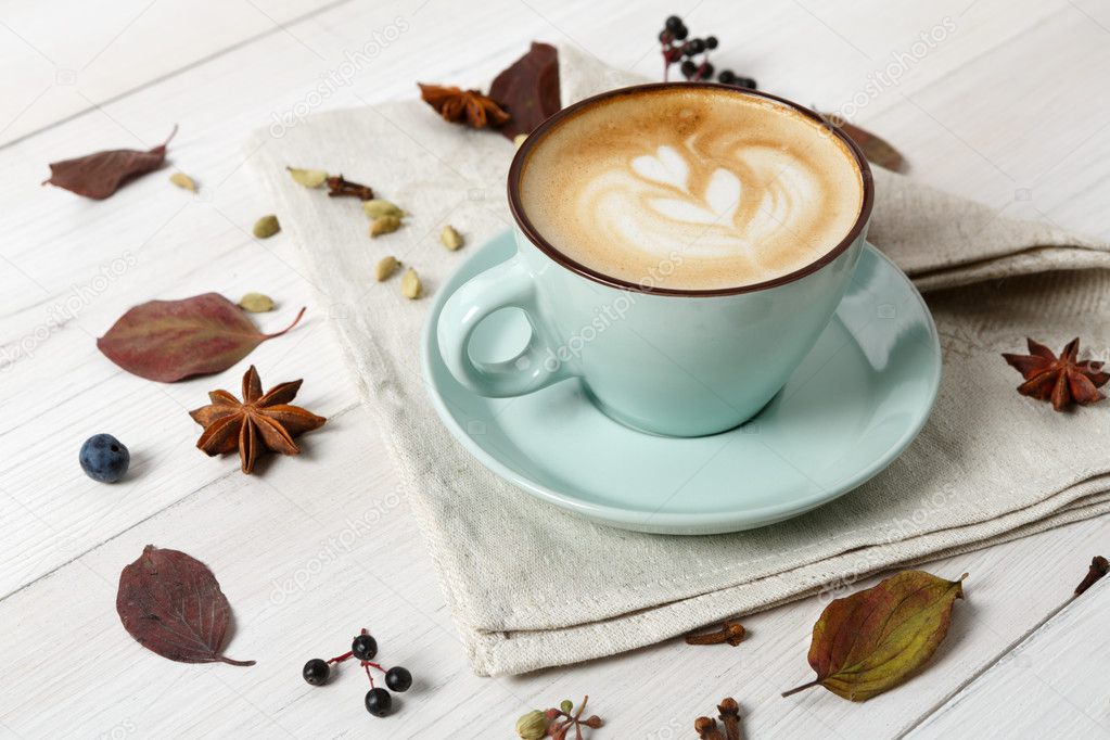 Autumn cappucino coffee cup on white wood background