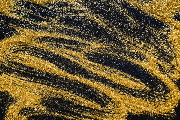 Pittura a sabbia. Glitter dorati sparsi su sfondo nero e astratto . — Foto Stock