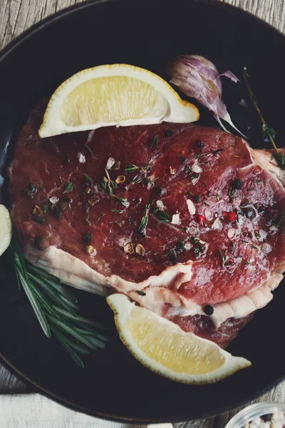 Steak de boeuf cru fond de gros plan avec des épices et des herbes . — Photo