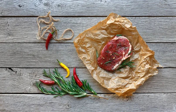 Syrové hovězí steak na pozadí tmavě dřevěný stůl, pohled shora — Stock fotografie