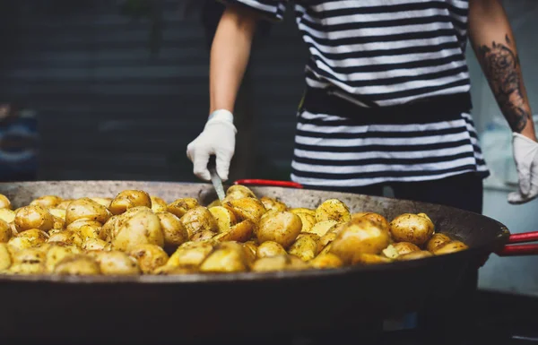 Roasted potatoes cooked in metal cauldron pot — Stock Photo, Image