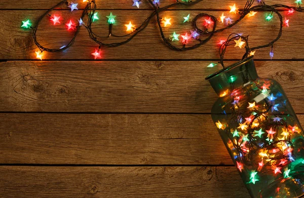 Christmas lights border on wood background — Stock Photo, Image