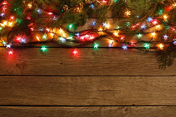 Luzes de Natal fronteira no fundo de madeira — Fotografia de Stock