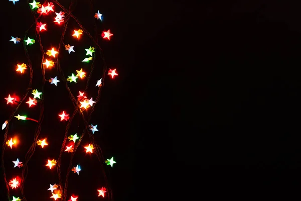 Luzes de Natal fronteira no fundo preto — Fotografia de Stock