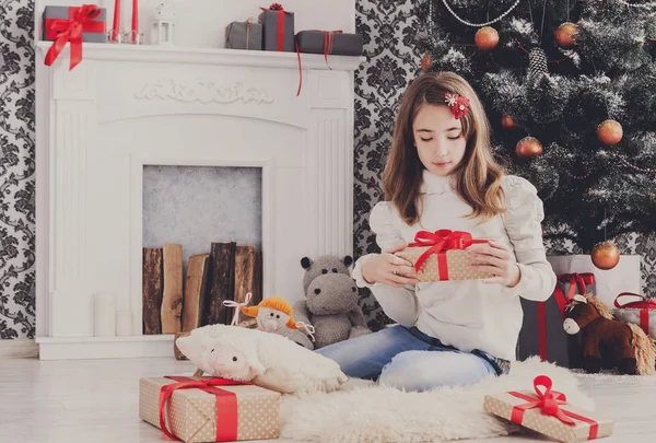 Bella ragazza in cappello di Babbo Natale scartando regali di Natale — Foto Stock