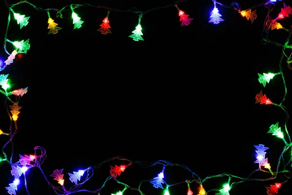 Christmas lights border on black background — Stock Photo, Image