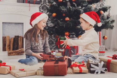 Mutlu çocuklar santa şapka çıkartıyorum Noel hediyeleri