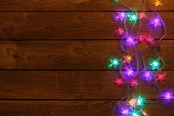 Luzes de Natal fronteira no fundo de madeira — Fotografia de Stock
