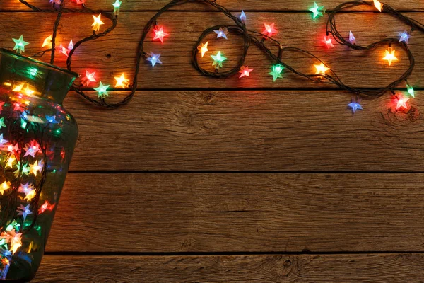 Christmas lights border on wood background — Stock Photo, Image