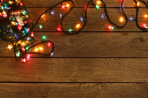 Christmas lights border on wood background — Stock Photo, Image