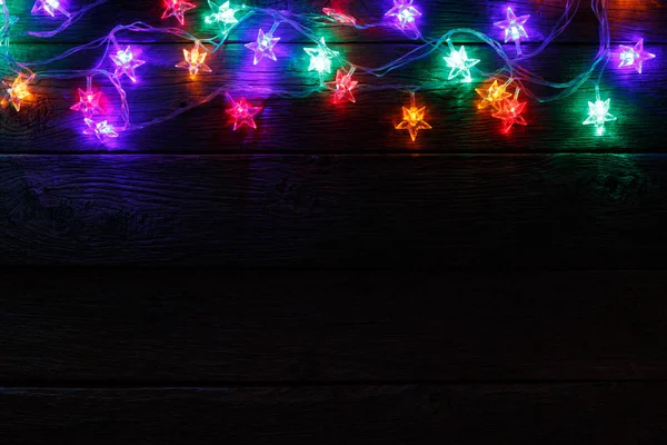 Boże Narodzenie światła granicy na czarnym tle drewna — Zdjęcie stockowe