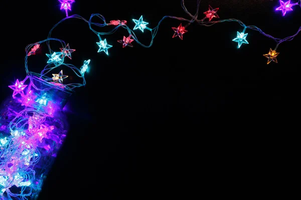 Christmas lights sterren grens op zwarte achtergrond — Stockfoto