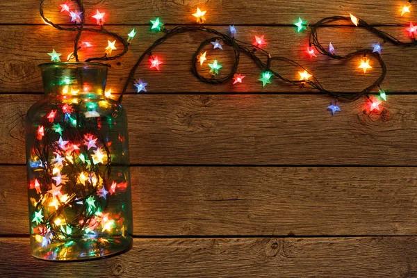 Christmas lights border on wood background — Stock Photo, Image