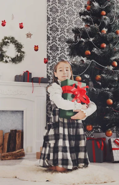 Hermosa niña y regalo de Navidad en el interior —  Fotos de Stock