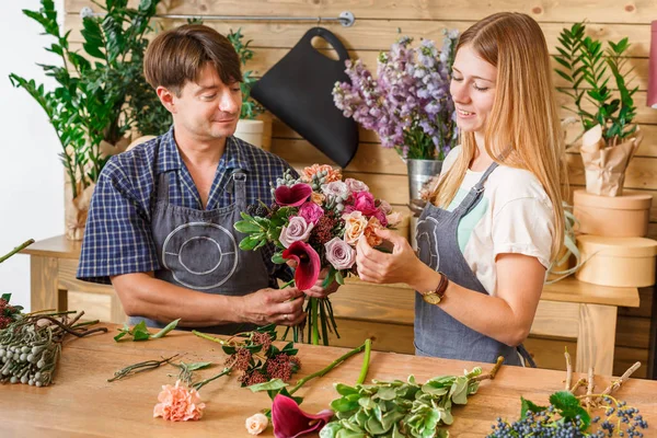 Floristería y asistente en la entrega de la tienda de flores hacer ramo de rosas —  Fotos de Stock