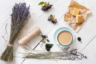 Beyaz ahşap üzerine sütlü kahve ve çiçek kompozisyon