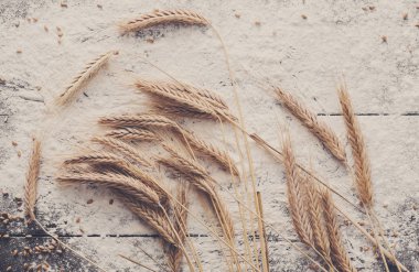 Kavram ahşap arka plan üzerinde pişirme, buğday kulakları ile un serpilir