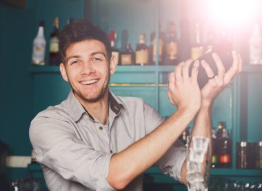 Genç yakışıklı barmen içinde Bar sallayarak ve alkol kokteyl karışımı