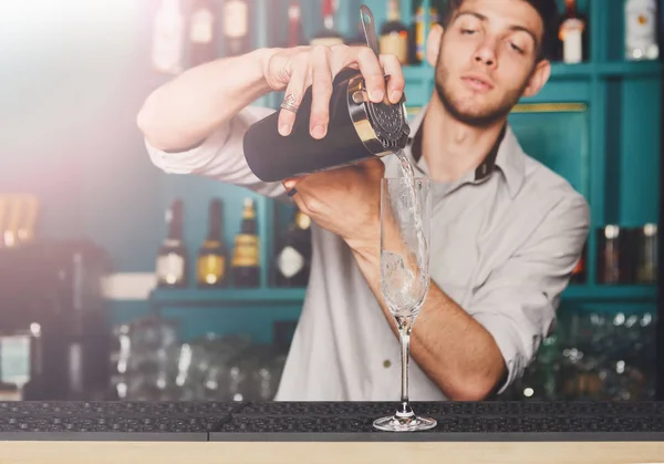 Joven barman guapo vertiendo bebida de cóctel en el vaso — Foto de Stock