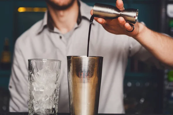 Young Barmans maken cocktail, gieten van alcohol in glas — Stockfoto
