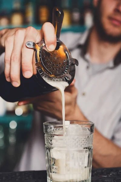 Barmans jóvenes haciendo cóctel de tiro, vertiendo jarabe en el vaso — Foto de Stock