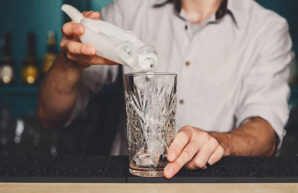 Barmans manos vertiendo hielo para cóctel — Foto de Stock