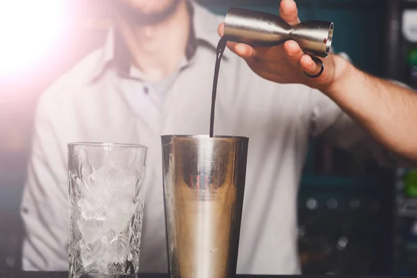 Young Barmans maken cocktail, gieten van alcohol in glas — Stockfoto