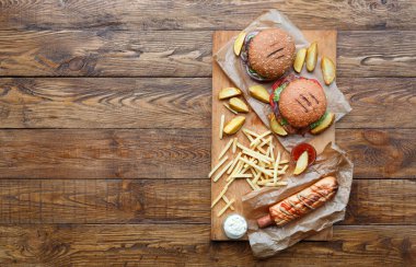 Fast food yukarıdan ahşap üzerine. Hamburger, sosisli ve patates