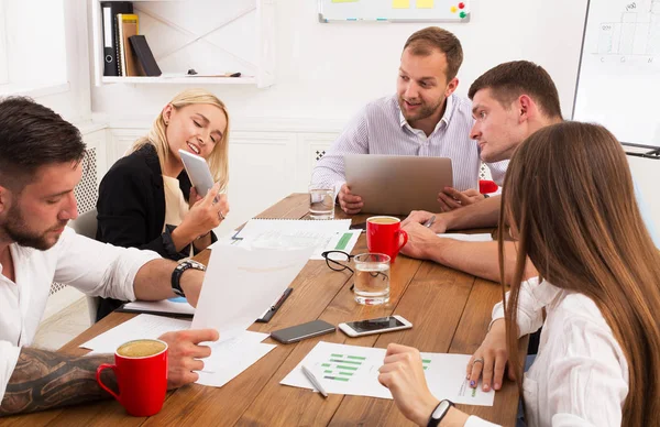 Zakelijke bijeenkomst. Jonge hipsters zakenmannen en -vrouwen op moderne kantoor — Stockfoto