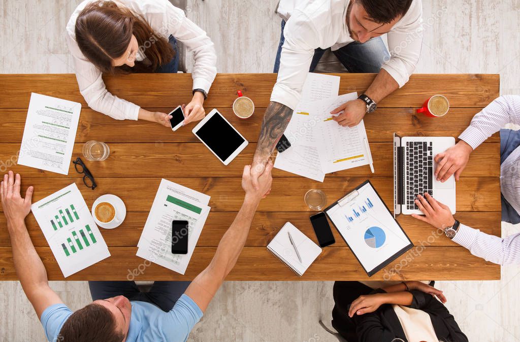 Business people group handshake in office, top view