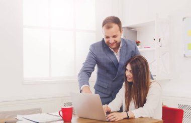 İş işadamı kadın yardımcıları denetliyor üstünde laptop