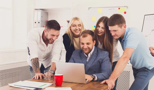 Feliz equipo de gente de negocios juntos mirar a la computadora portátil en la oficina — Foto de Stock