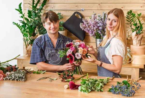 Floristería y asistente en la entrega de la tienda de flores hacer ramo de rosas —  Fotos de Stock