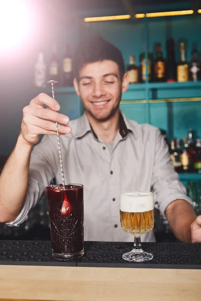 Joven barman guapo vertiendo bebida de cóctel en el vaso — Foto de Stock